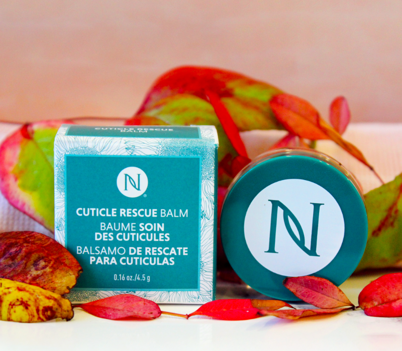 Neora's Cuticle Rescue Balm sitting in a bed of spring flowers.